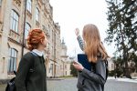 Two students standing outside university campus